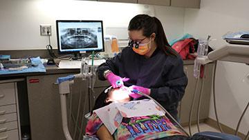 Dental Hygienist cleaning a patient's teeth.